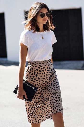 Outfit kaos putih wanita dengan rok motif leopard